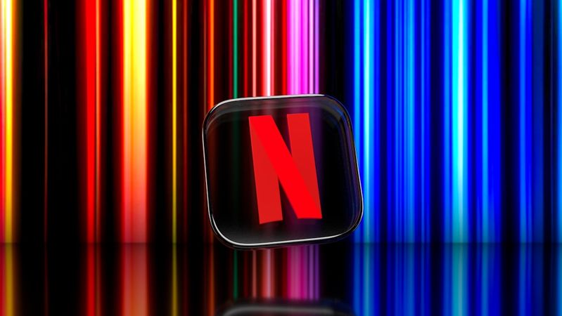 The image features the Netflix logo prominently displayed against a backdrop of colorful vertical light bars. The glossy surface reflects the logo, highlighting its vibrant colors.