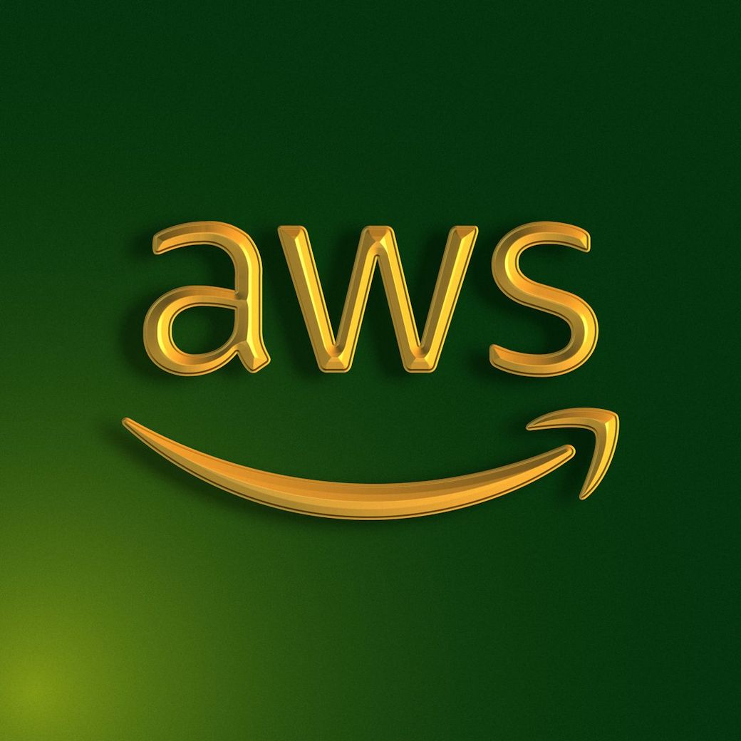 The image features the Amazon Web Services (AWS) logo, prominently displayed with a green background. The logo includes the letters 'aws' in a yellowish hue, accompanied by a curved arrow resembling a smile, symbolizing Amazon's customer-focused approach. — Credit: Photo by Woliul Hasan on Unsplash