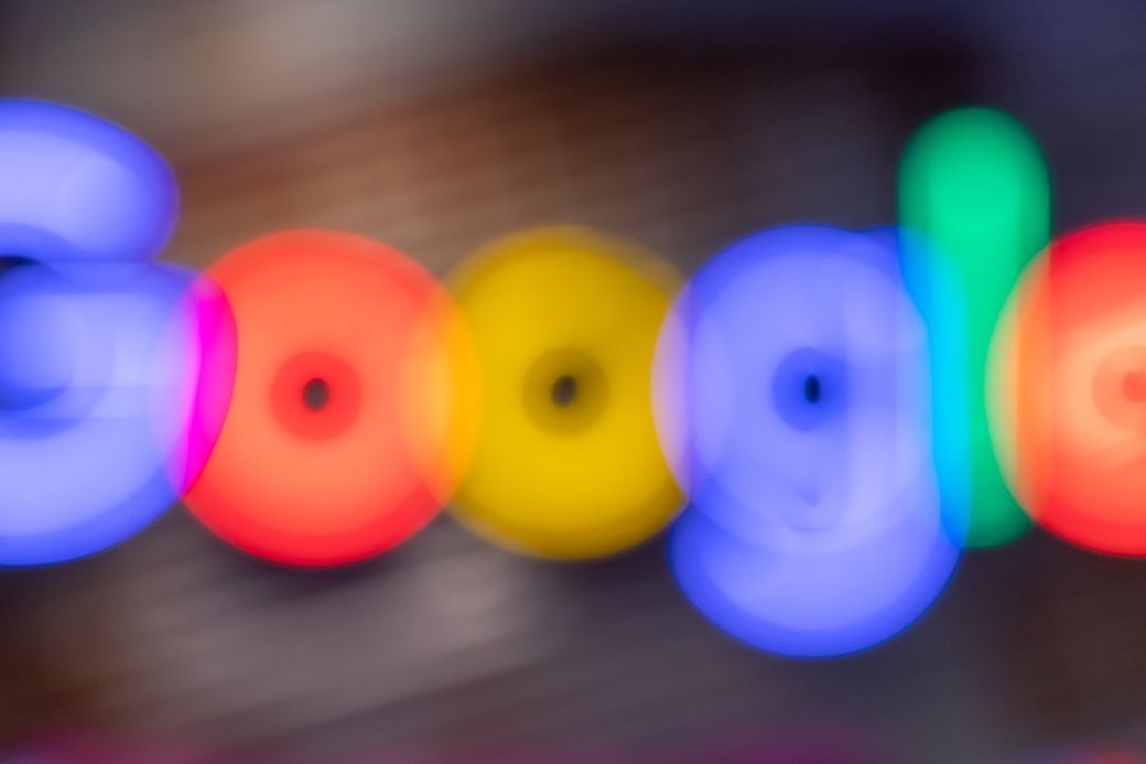 The image features a blurred representation of the Google logo, with vibrant colors capturing the essence of the brand. The soft focus creates a dreamy, abstract portrayal that emphasizes the colorful aspect of the logo. — Credit: Photo by Mitchell Luo on Unsplash