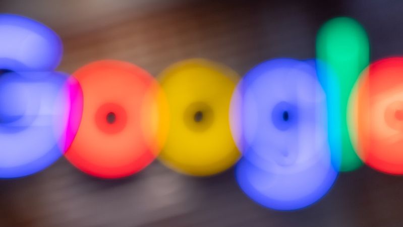 The image features a blurred representation of the Google logo, with vibrant colors capturing the essence of the brand. The soft focus creates a dreamy, abstract portrayal that emphasizes the colorful aspect of the logo.