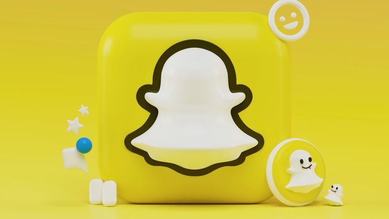 The image features a stylized representation of the Snapchat logo against a bright yellow background. Accompanying the logo are various playful elements, including smiley faces and stars, enhancing its vibrant and youthful appeal.