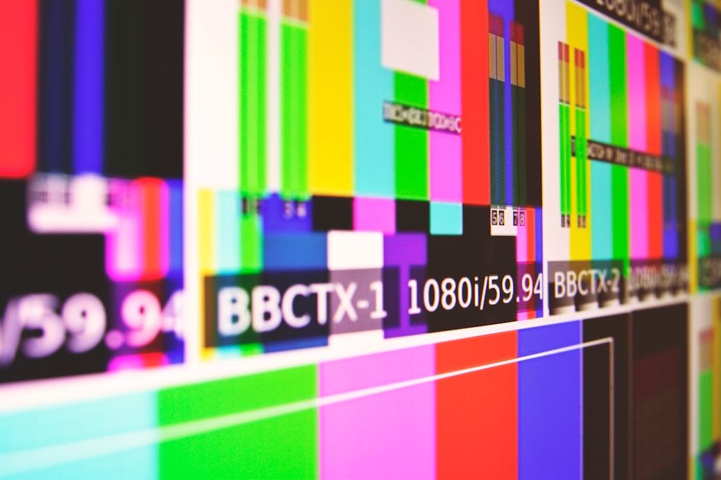 The image displays a screen filled with various color bars and test patterns typically used in television and video production. The visual showcases a technical setup, likely used for testing broadcast signals and display calibration. — Credit: Photo by Tim Mossholder on Unsplash