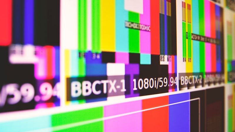 The image displays a screen filled with various color bars and test patterns typically used in television and video production. The visual showcases a technical setup, likely used for testing broadcast signals and display calibration.
