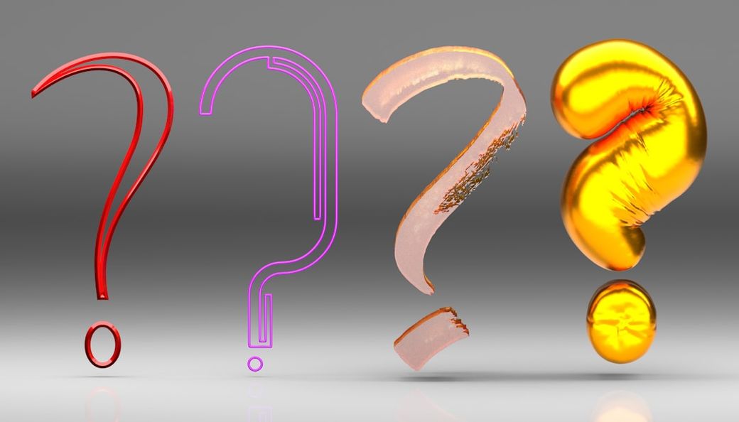 The image features four stylized question marks, each with distinct textures and colors. The question marks are placed against a neutral gray background, emphasizing their artistic design. — Credit: Photo by Buddha Elemental 3D on Unsplash
