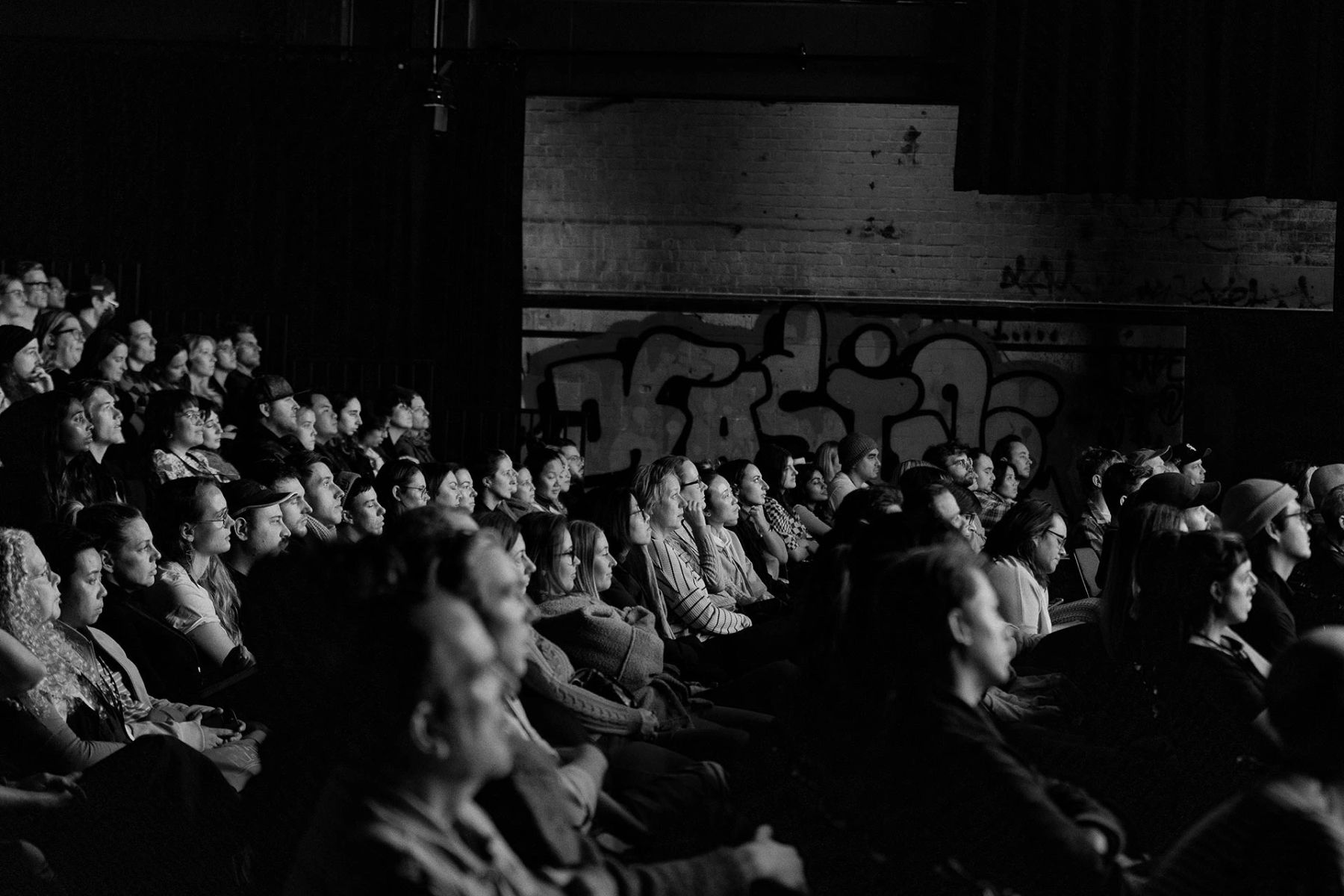 Black and white photo of an audience seated in the Brisbane Powerhouse amphitheatre during The Design Conference