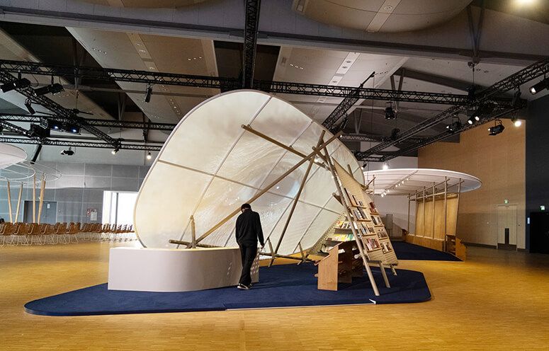 The Philippine Pavilion’s sail-like canopy with bamboo ladders and rattan seating inside a Frankfurt hall