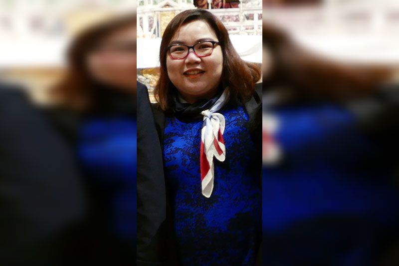 Vice Consul Awee Dacanay in a blue print dress and patterned scarf