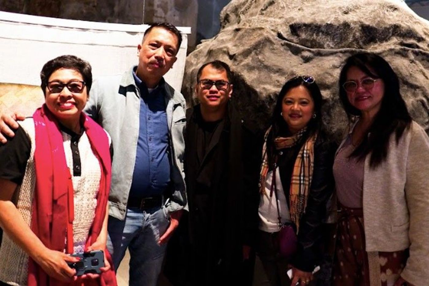 A group of five Filipino guests posing together inside the historic brick exhibition hall in Italy