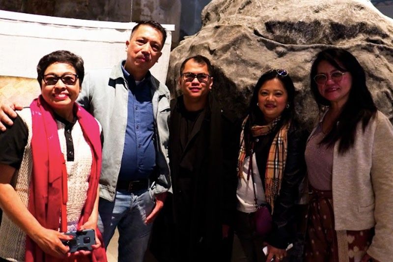 A group of five Filipino guests posing together inside the historic brick exhibition hall in Italy