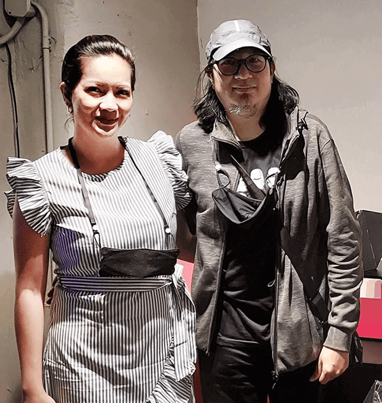 Joanne Enriquez in a striped ruffled dress with Julius Sanvictores in a cap and gray hoodie
