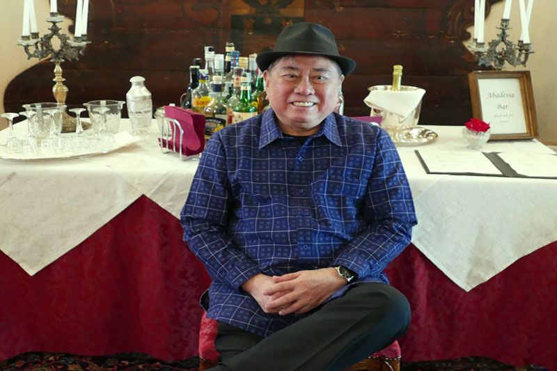 Virgilio Almario in a hat and checked shirt, seated at the Abadessa bar in Venice