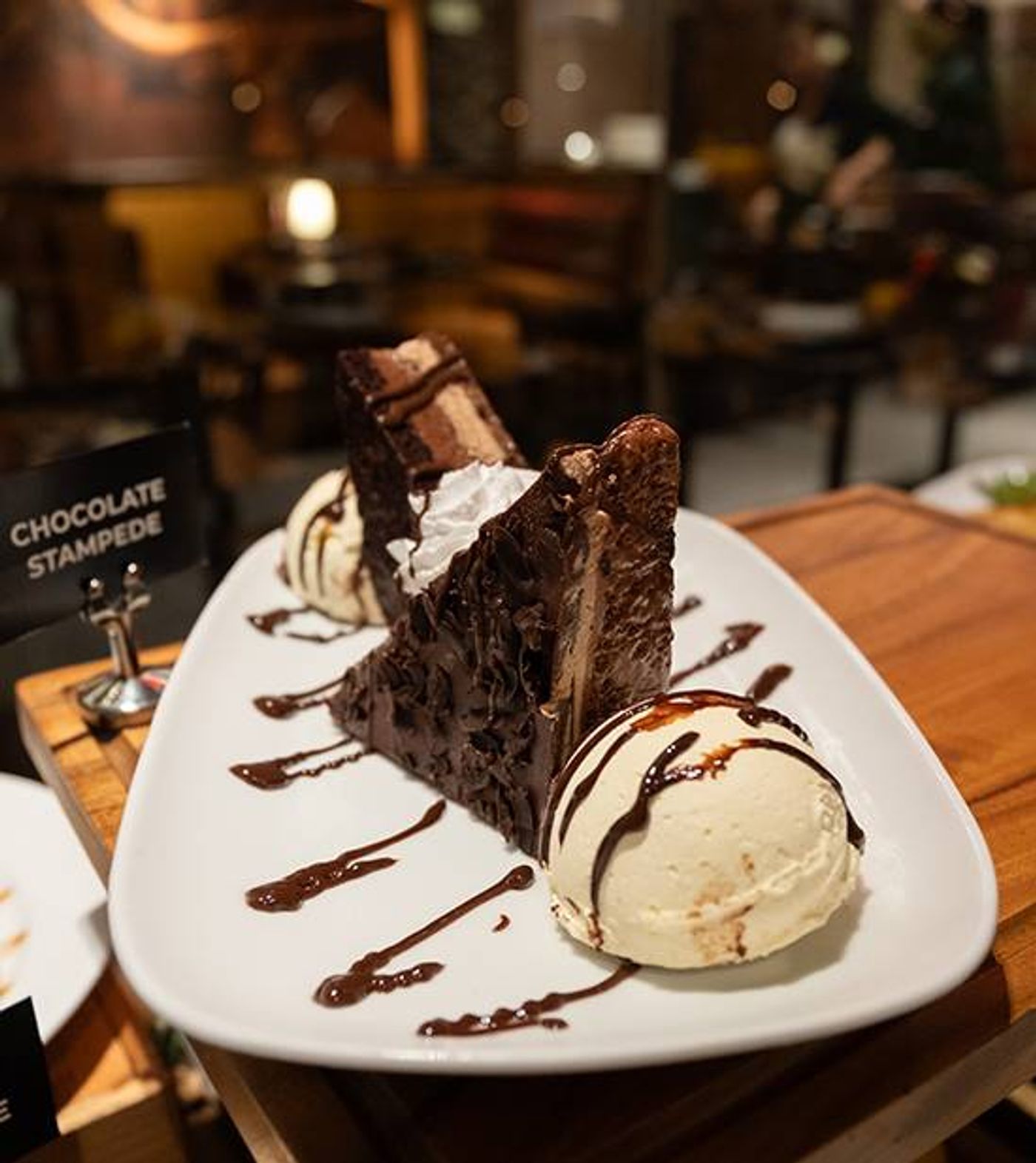Chocolate Stampede: layered chocolate cake wedges with vanilla ice cream and fudge drizzle