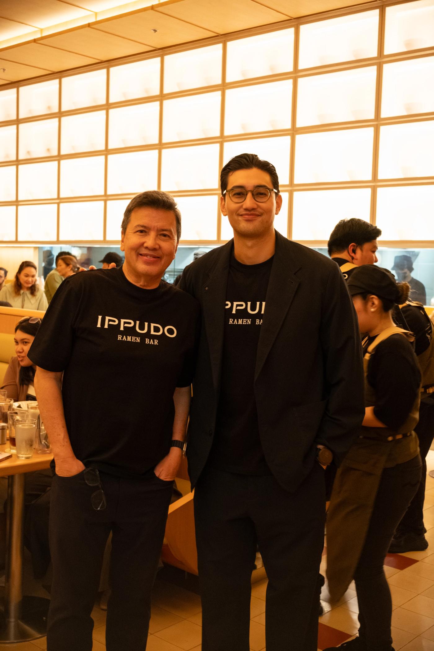 John and Michael Concepcion in black Ippudo Ramen Bar shirts inside the brightly lit restaurant