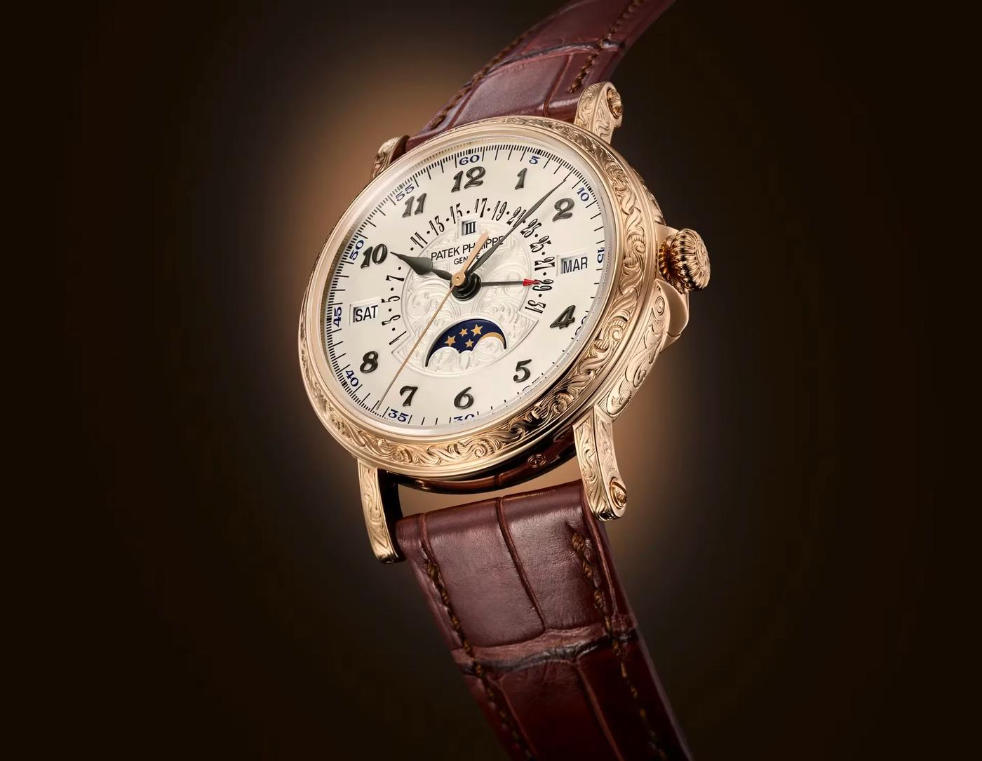 Front view of the Patek Philippe Ref. 5160/500R-001 rose gold perpetual calendar watch featuring intricate hand-engraved casing and a brown leather strap