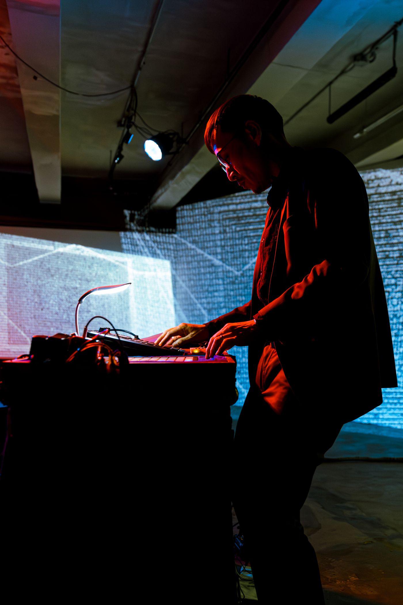 Marco Ortiga adjusting electronics and wires on his lap steel guitar instrument on stage