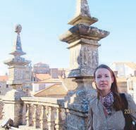 Tour guide Virginia González Quintana beside carved stone pinnacles on the Santiago Cathedral rooftop