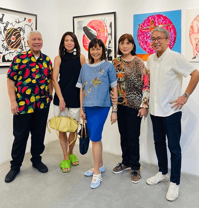 PR maven Edd Fuentes, Tats Manahan, Trickie Lopa, Millet Mananquil, and Sari Ortiga posing together in front of a giant orange donut painting at the art exhibition