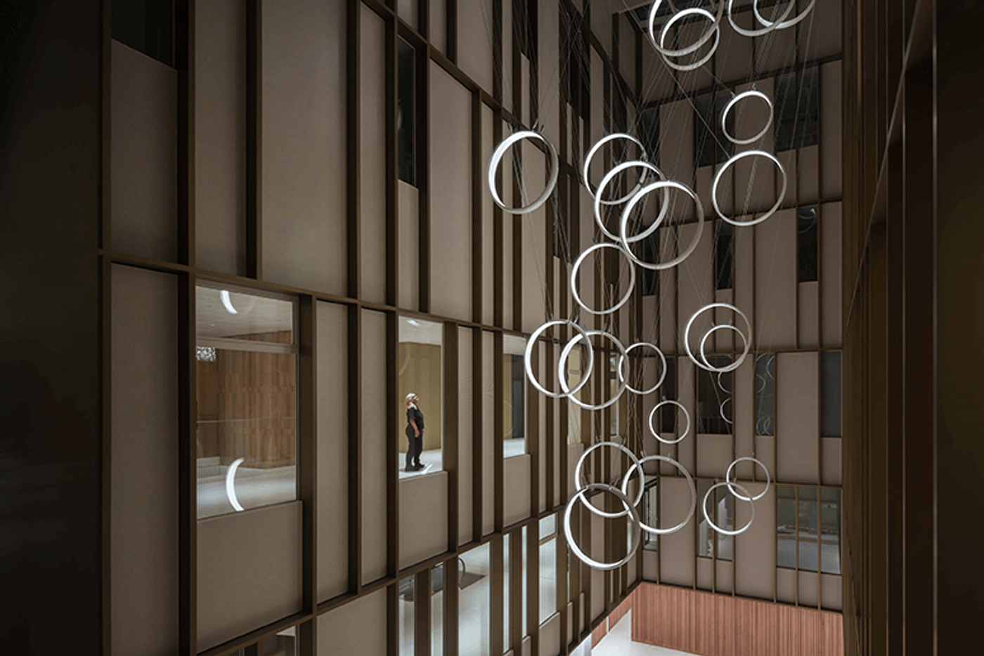 Rings of suspended kinetic elements spiral through the atrium of Inselspital hospital in “Loops”