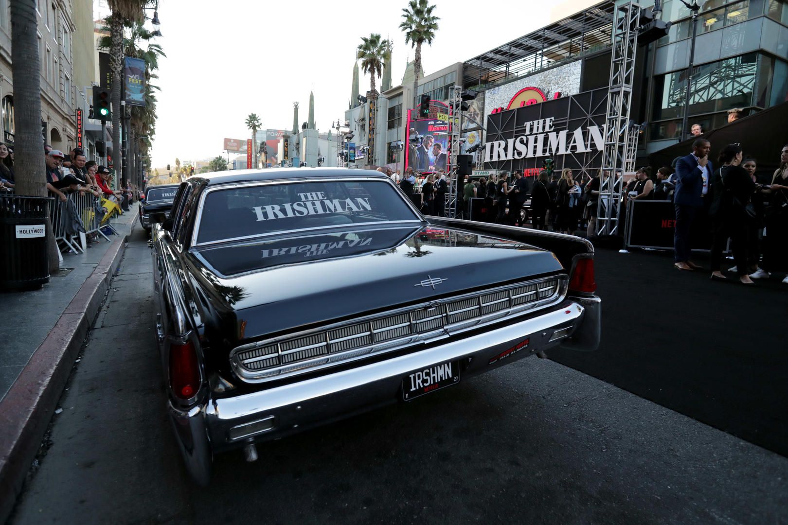 Vintage black sedan with The Irishman branding rolls past fans outside the TCL Chinese Theatre