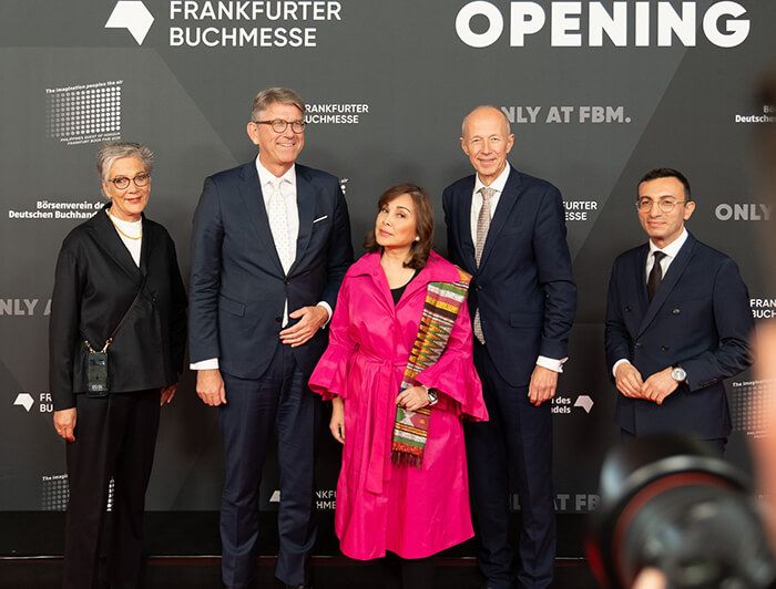 Senator Legarda in a bright pink coat flanked by German officials on the Frankfurter Buchmesse red carpet