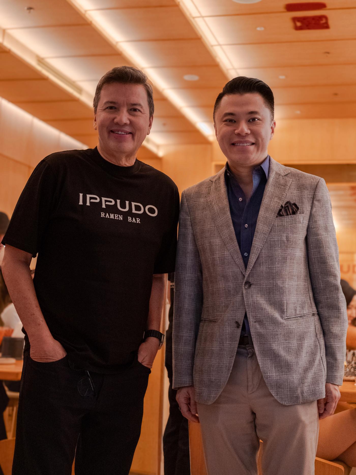 John Concepcion in an Ippudo shirt standing beside Kevin Tan in a gray plaid blazer at the restaurant