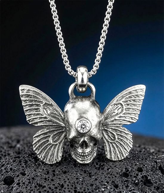 Oxidized silver skull pendant by Michelline Syjuco with butterfly wings, on a box chain