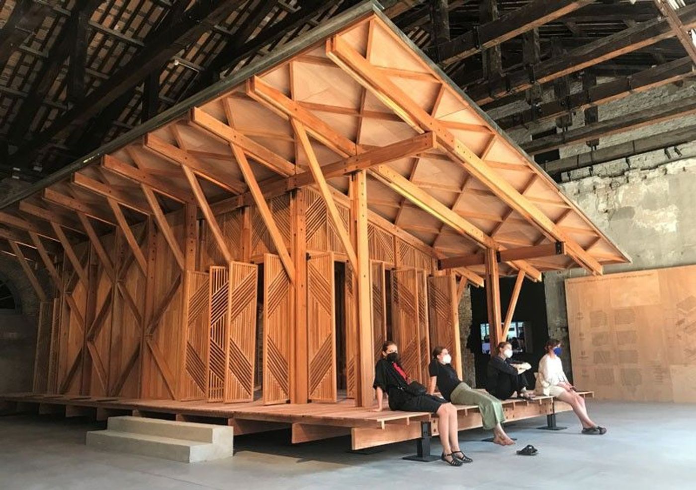 Interior of the Philippine Pavilion at the Venice Architecture Biennale featuring the wooden library structure and daily visitors