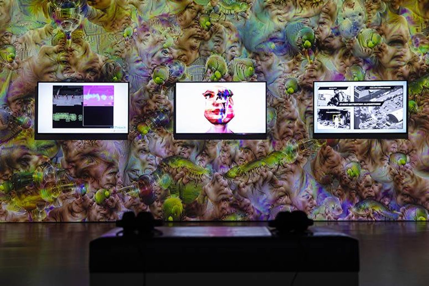 Three video screens on a wall of swirling DeepDream faces in Zach Blas and Jemima Wyman’s installation