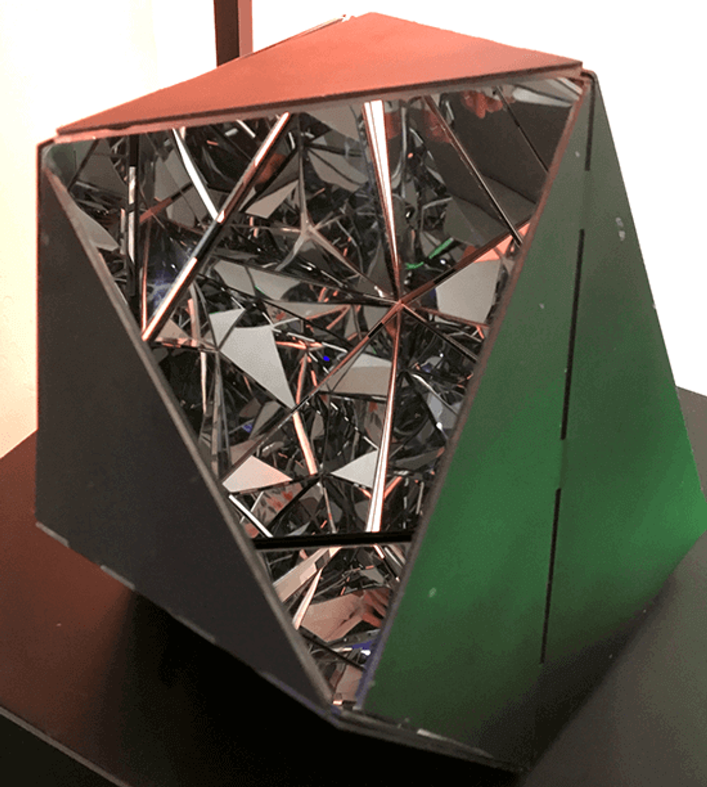 From Marco Ortiga’s Diamonds in the Rough series, a dark faceted polyhedron opened to a triangular chamber of mirror shards