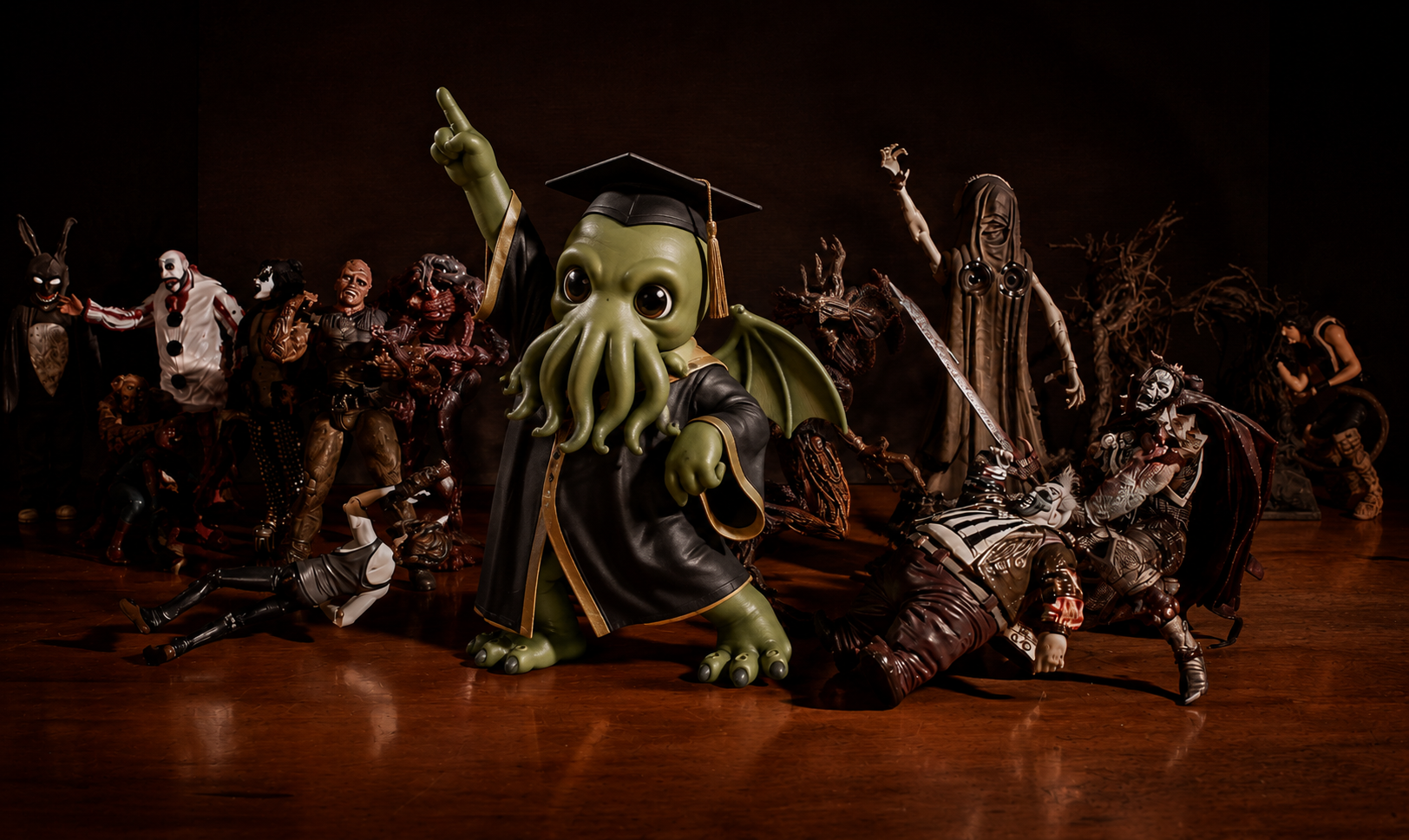 Cthulhu figurine in a graduation cap and gown striking a disco pose, one arm raised, before a crowd of horror-figure toys on a wooden floor