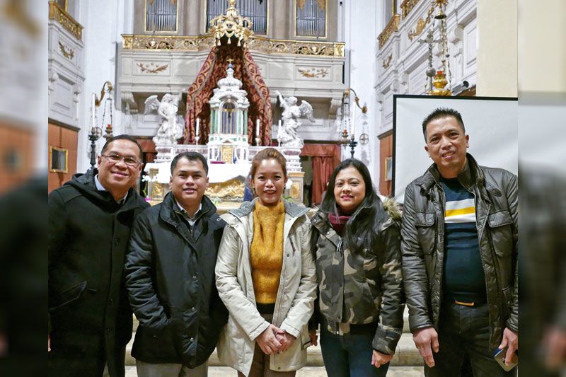 Darwin Gutierrez with members of the Filipino community in Treviso before a church altar in Venice