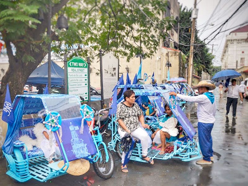 Row of bright blue pedicabs lined up on a street in Intramuros during the Manila Biennale