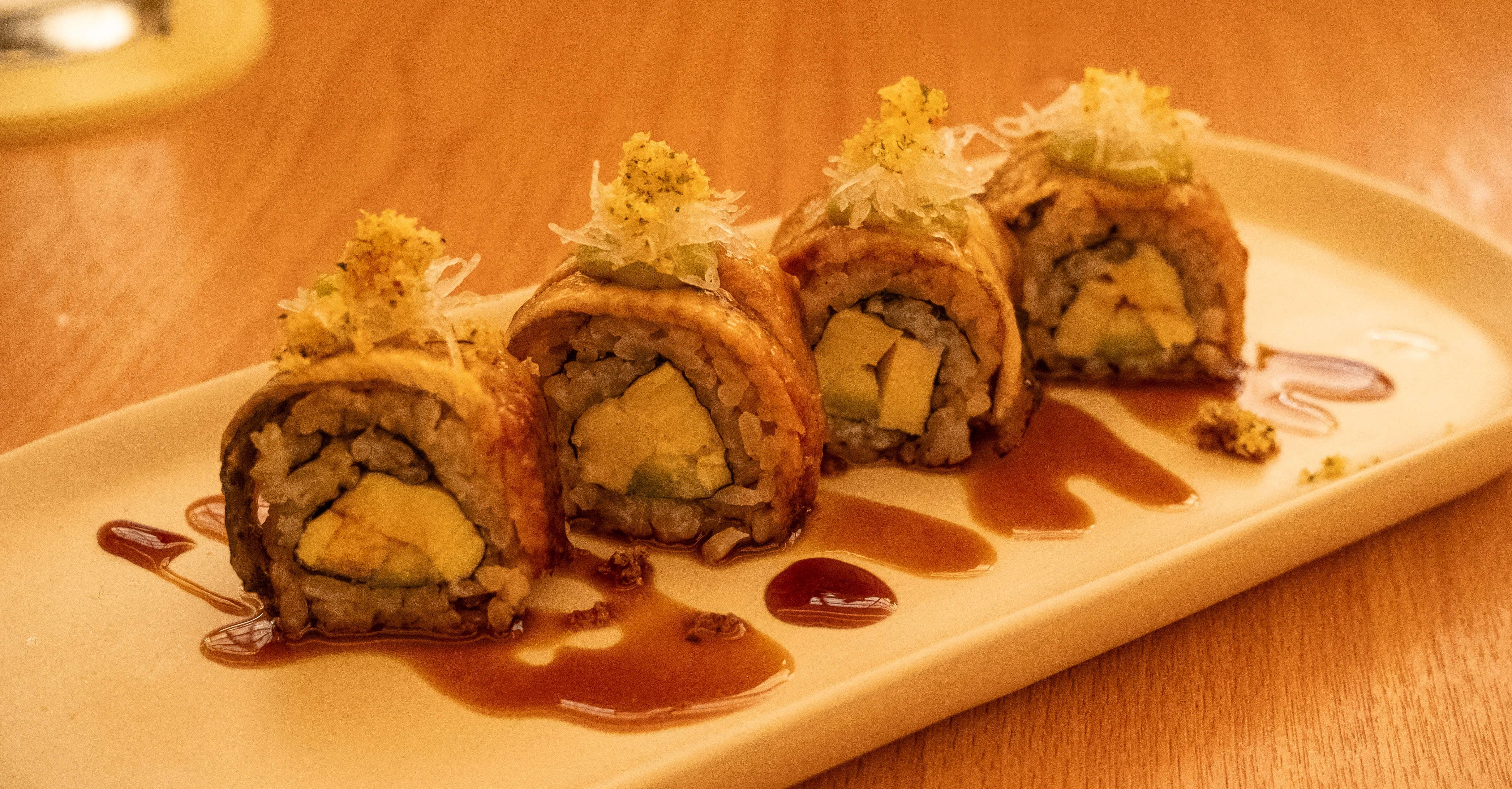 Ippudo’s unagi tamago roll, four pieces topped with shredded daikon and golden crumb over swirls of eel sauce