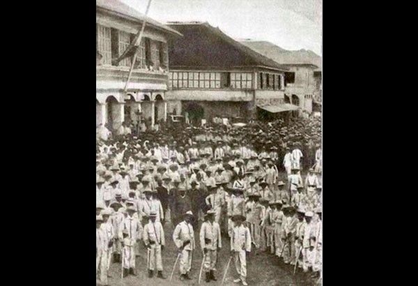 Filipino revolutionary troops massed with rifles in an Iloilo plaza before a colonial house, the victorious Ilonggos on Christmas Day of 1898