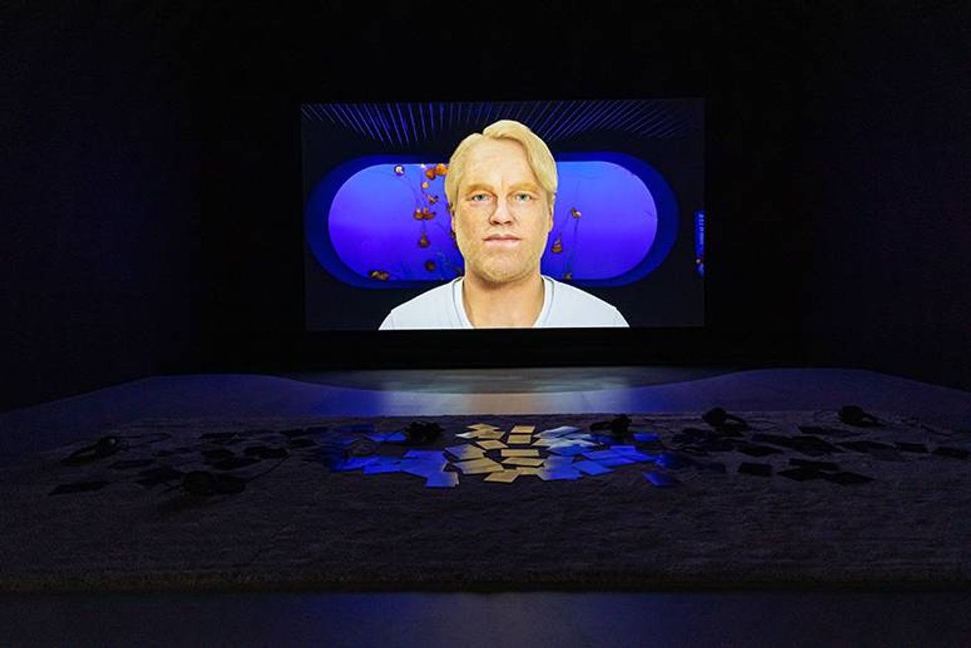 Installation view of Cecile B. Evans’ Hyperlinks or it didn’t happen, a rendered blond figure on a dark room’s screen