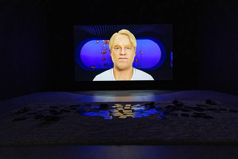 Installation view of Cecile B. Evans’ Hyperlinks or it didn’t happen, a rendered blond figure on a dark room’s screen