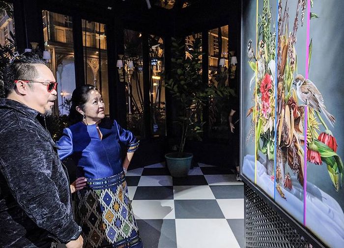 Artist Olan Ventura and First Lady Liza Araneta-Marcos standing together in front of a colorful, deconstructed floral painting at Goldenberg Mansion
