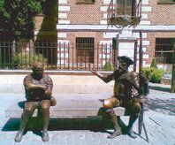 Bronze statues of Don Quixote and Sancho Panza seated on a bench outside the Cervantes house in Alcalá de Henares