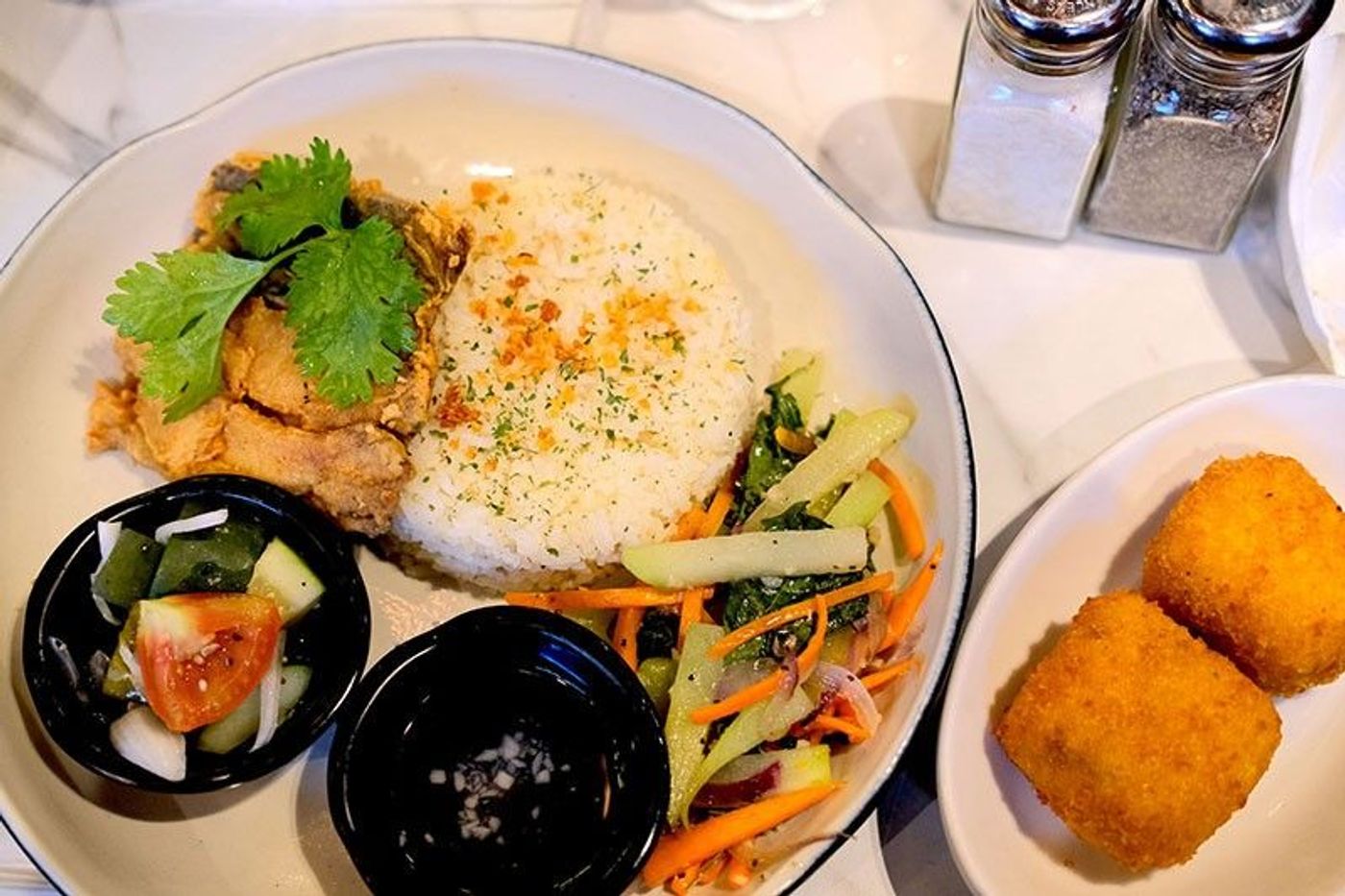 TGI Fridays set meal featuring crispy smoked fish over white rice served next to a portion of fried mac-and-cheese bites