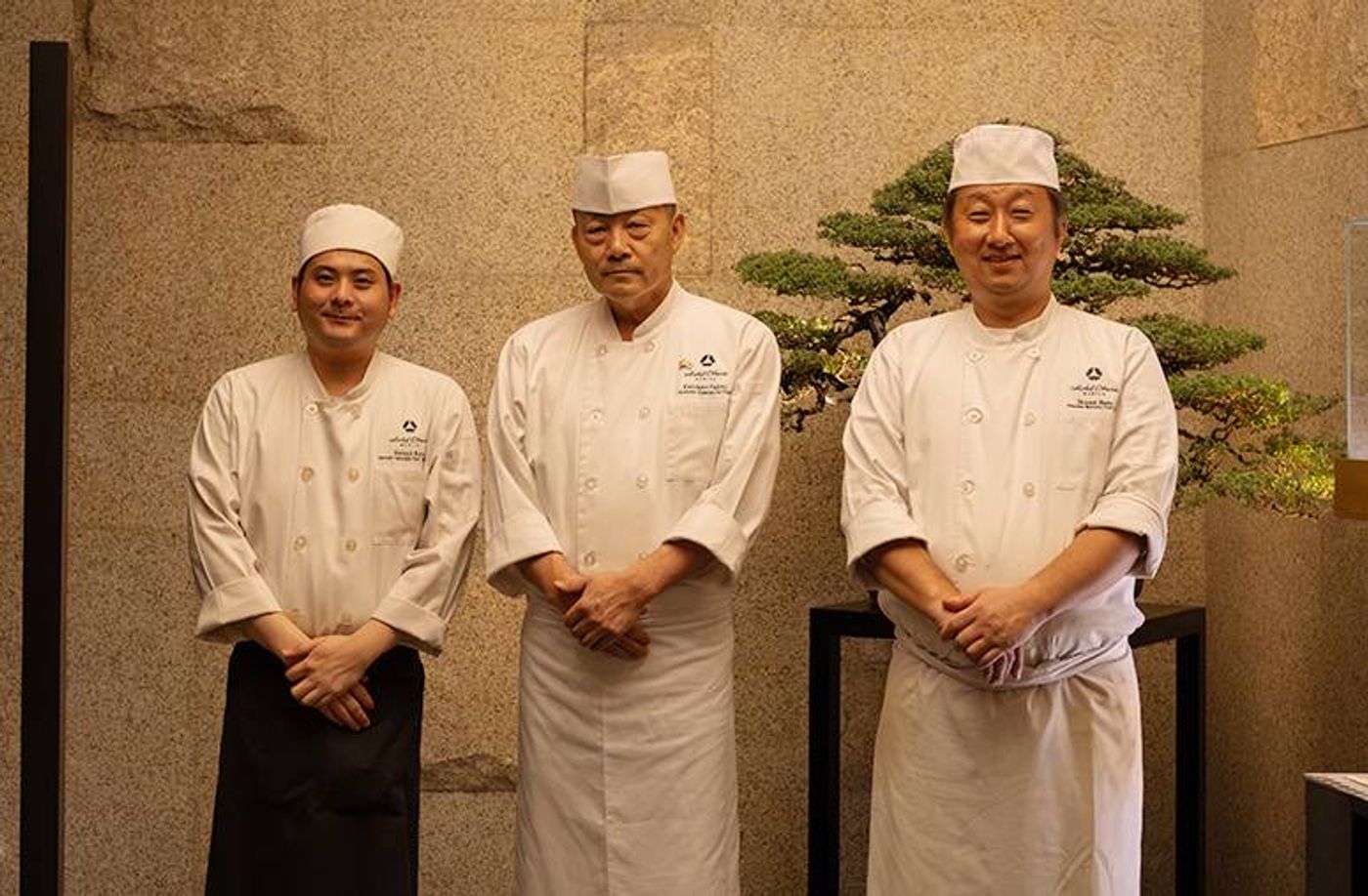 Yamazato’s three Japanese chefs pose in white uniforms before a bonsai at Hotel Okura Manila