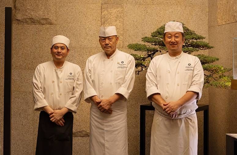 Yamazato’s three Japanese chefs pose in white uniforms before a bonsai at Hotel Okura Manila