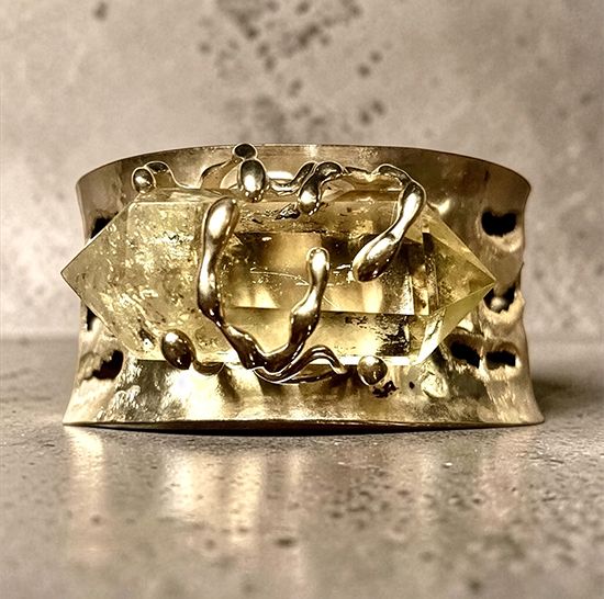 Hammered gold-toned cuff by Michelline Syjuco with sculpted tendrils gripping a double-terminated citrine crystal