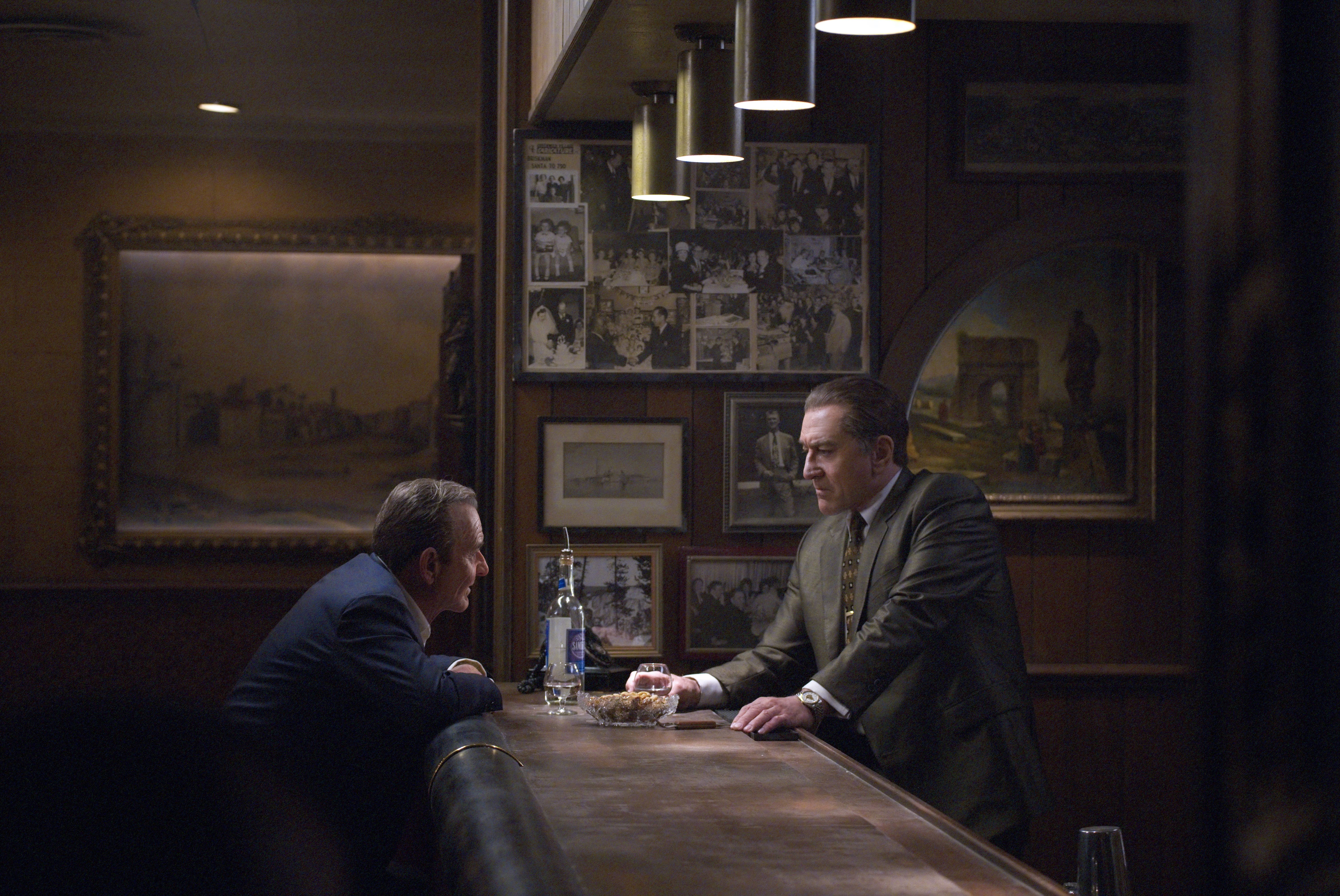Robert De Niro and Joe Pesci share a quiet word across the bar in a scene from The Irishman