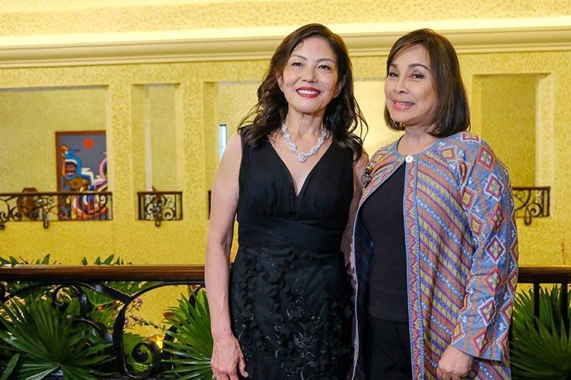 Cecile Licad in a black dress and diamond necklace beside Senator Loren Legarda in a woven patterned coat