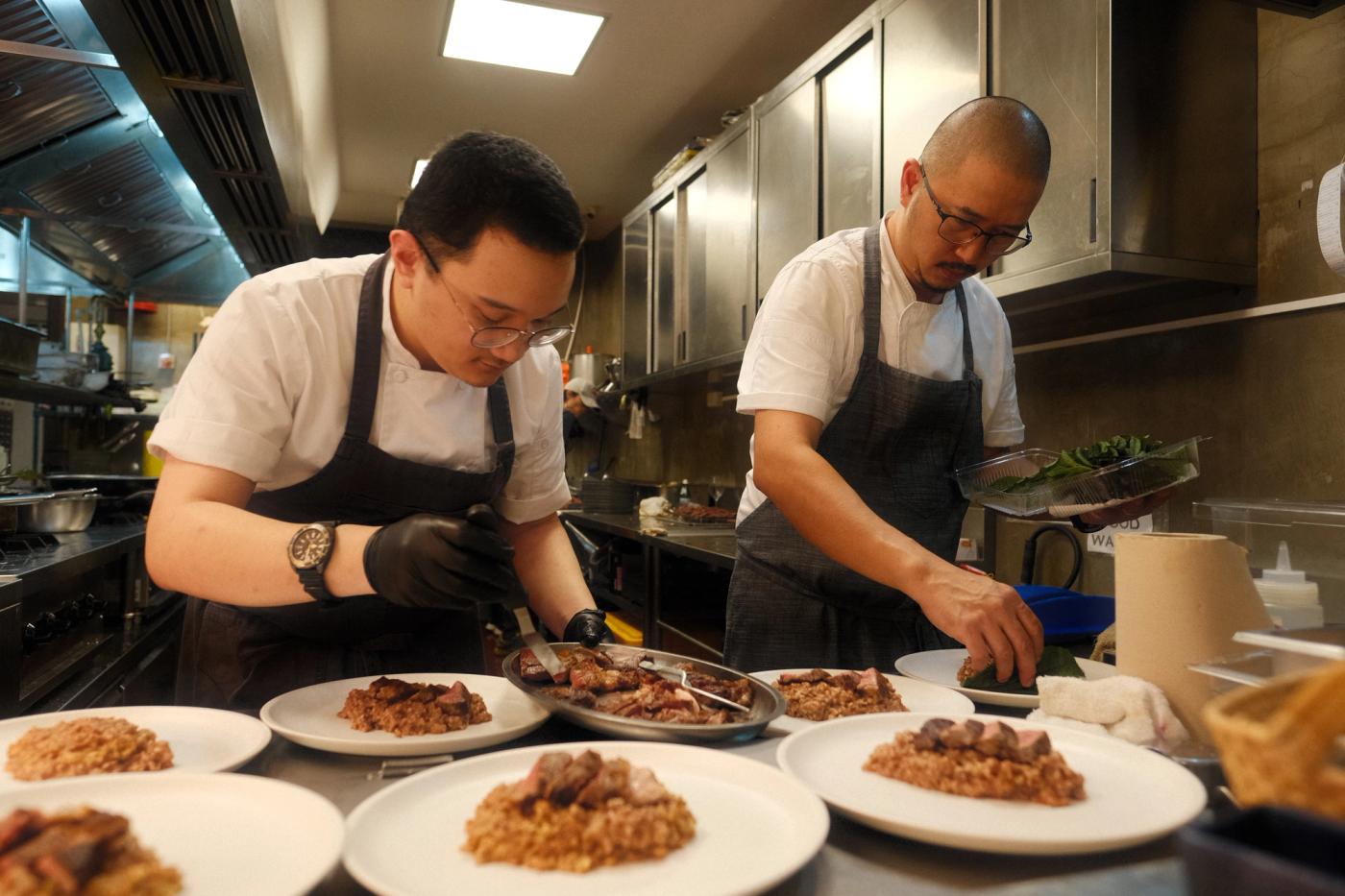 Chef Jeramie Go of Pilgrim Davao and his son sous chef Noah Go plating dishes in the restaurant kitchen