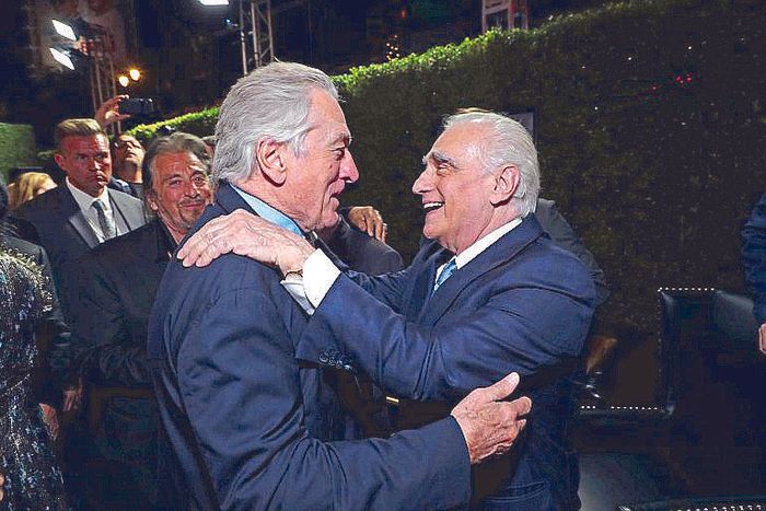 Robert De Niro and Martin Scorsese embrace, laughing, amid the crowd at the Los Angeles premiere