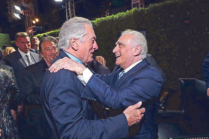 Robert De Niro and Martin Scorsese embrace, laughing, amid the crowd at the Los Angeles premiere