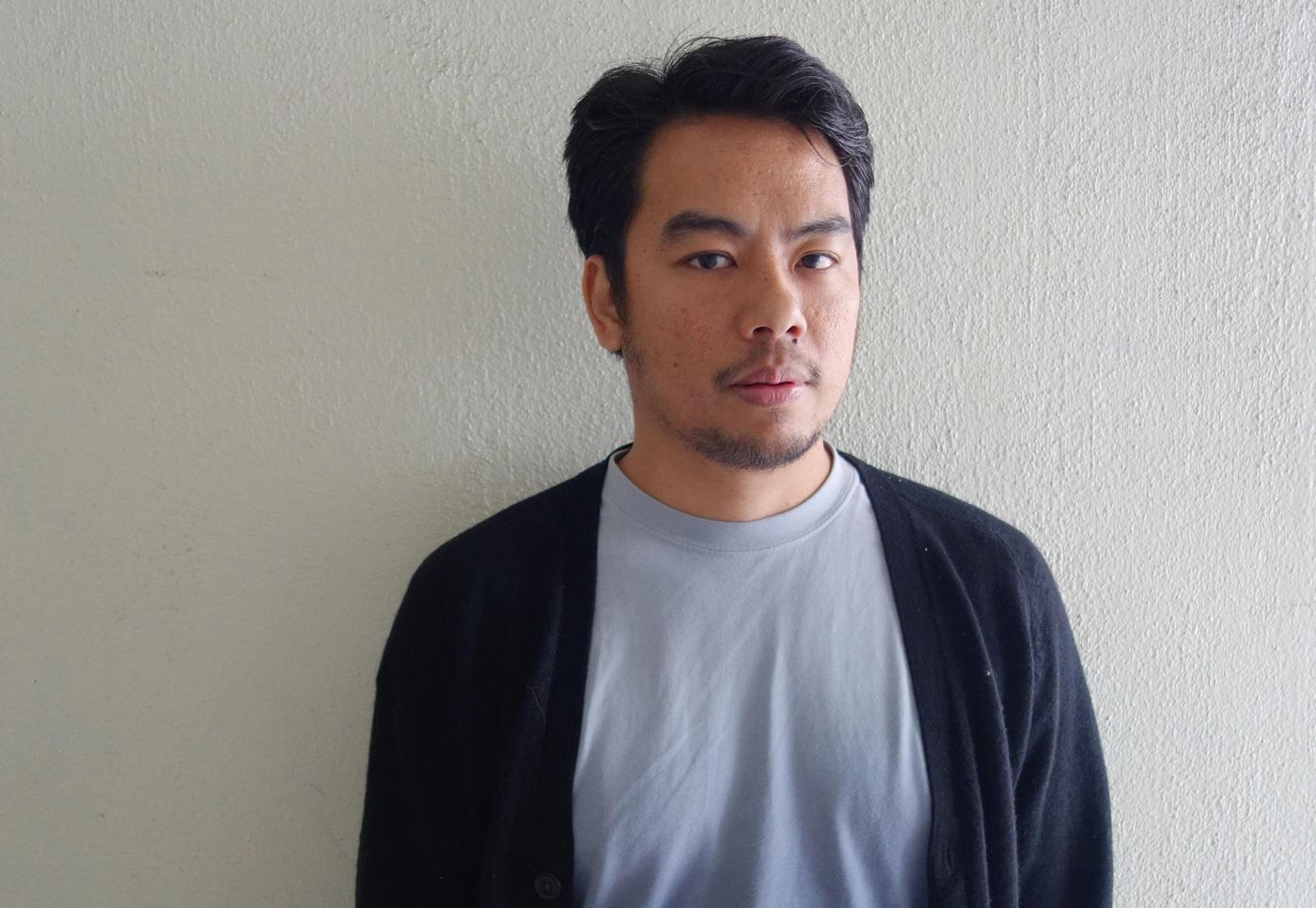 Portrait of contemporary artist Mark Salvatus posing with a thoughtful expression
