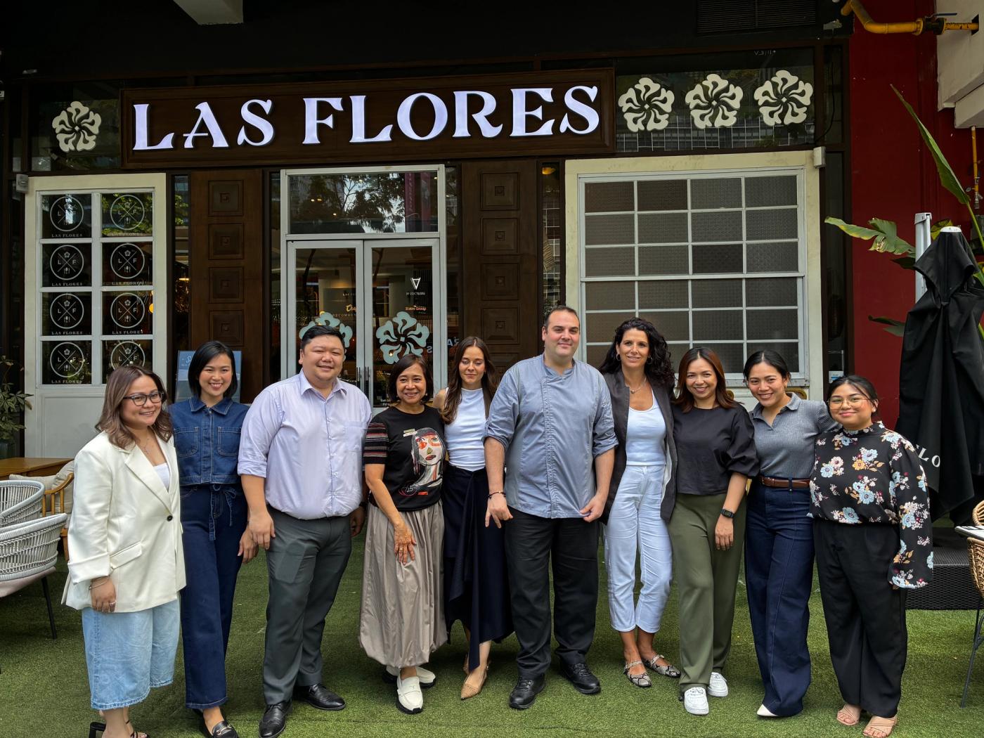 Team Bistronomia lined up outside Las Flores restaurant beneath its white-lettered facade