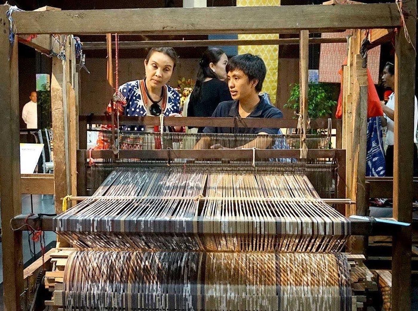 Deputy Speaker Loren Legarda posing with weaver Sammy Buhle and team members in front of a woven textile installation in Venice